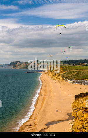 Eine Gruppe von Gleitschirmen über die Klippen bei Burton Bradstock auf der Jurassic Coast, Dorset, England, Großbritannien Stockfoto