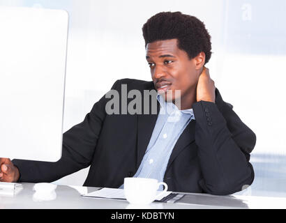 Porträt eines Geschäftsmannes Nackenschmerzen im Büro leiden Stockfoto