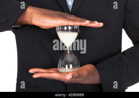 Nahaufnahme des afrikanischen Geschäftsmann Sanduhr In Händen halten Stockfoto