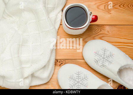 Einen warmen Pullover und gemütliche Hausschuhe mit einem heißen Kaffee top View Stockfoto