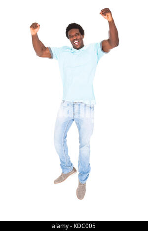 Aufgeregt casual jungen afrikanischen Mann ballte seine Faust isoliert auf weißem Hintergrund Stockfoto