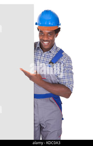 Handwerker hinter Plakat zeigt Thumb Up Sign Over White Background Stockfoto