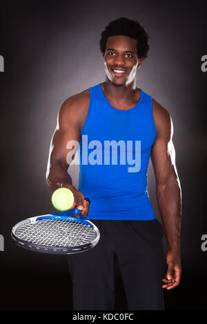 Junge Afrikaner Tennisspielen mit Tennisschläger Stockfoto