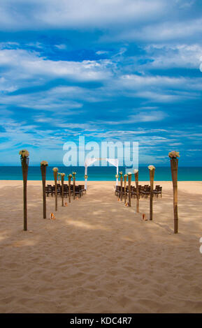 Tropische Hochzeit am Strand am Meer - mit blauem Himmel und kristallklarem Wasser an einem weißen Sandstrand Veranstaltungsort. Kerze und Shell Gang gesäumt. Stockfoto