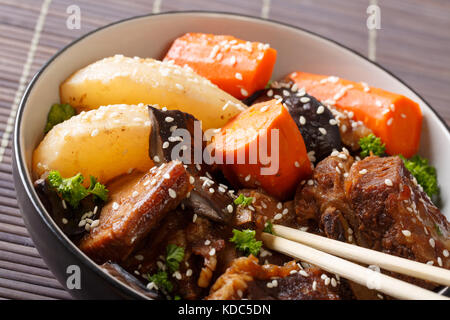 Die koreanische Küche: Rippen geschmort mit Pilzen, Birnen und Möhren close-up in eine Schüssel. Horizontale Stockfoto