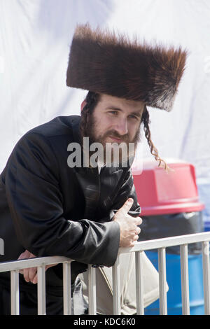 Einer chassidischen jüdischen Mann, der eine shtreimel Fell hat sich mit seiner Familie in einem Vergnügungspark in Brooklyn, New York. Stockfoto