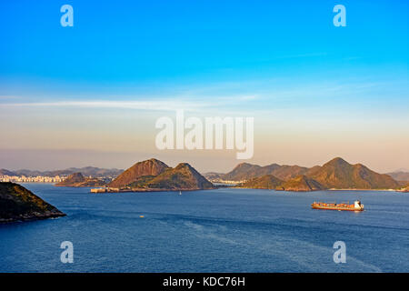 Frachtschiff am Eingang der Bucht von Guanabara in Rio de Janeiro mit niteroi Stadt im Hintergrund anreisen Stockfoto