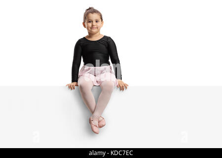 Kleine Ballerina sitzen auf einem Panel, und wenn man die Kamera auf weißem Hintergrund Stockfoto