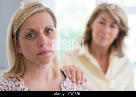 Reife Mutter über erwachsene Tochter zu Hause besorgt Stockfoto