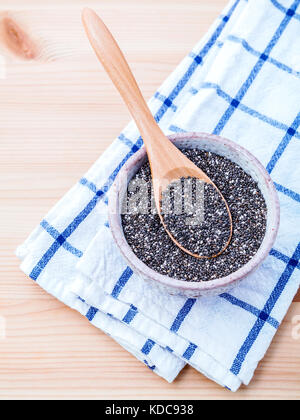 Nahrhafte Chia Samen in Keramik Schüssel für Ernährung Lebensmittel Zutaten setup auf Holz- Hintergrund. Stockfoto