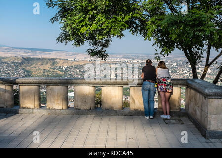 Paare genießen den Blick über die Stadt Tiflis, Georgien, Europa vom Seilbahn-Komplex, Mtatsminda Park. Stockfoto