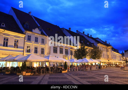 Restaurants auf dem großen Platz (Piaţa Mare) in der Abenddämmerung, in Sibiu in Siebenbürgen, Rumänien Stockfoto