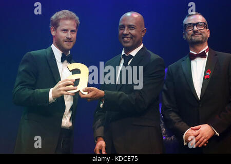 Der britische Prinz Harry (links) erhält im Namen seiner Mutter Diana, Prinzessin von Wales, von Ian Walker (rechts) und Julian La Bastide einen posthumen Vermächtnis-Preis bei den Attitude Awards in London. Stockfoto