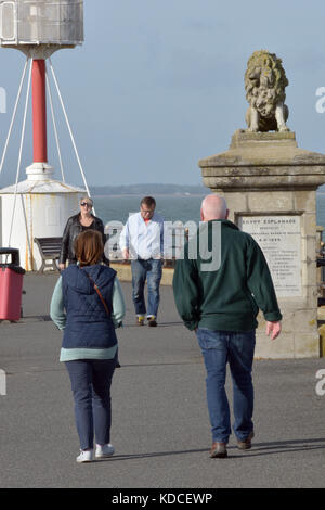 Ein Paar zu Fuß entlang der Strandpromenade oder Esplanade am Ägypten Punkt in Cowes auf der Isle of Wight mit einem anderen Paar zu Fuß in Richtung zu Ihnen im Herbst. Stockfoto