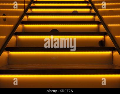Beleuchtete oder Neon farbige Treppe, markanten Hintergrund mit gelben und orangen Farben. Lustige mouseholes und LED-Beleuchtung. Stockfoto