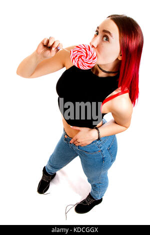 Lustige rothaarige Mädchen mit Lollipop auf weißem Hintergrund Stockfoto