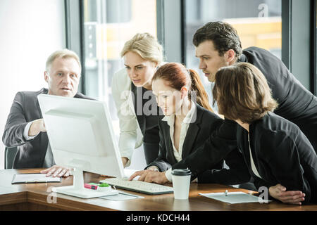 Business Team Blick bei einem Computermonitor in Diskussion im Büro Stockfoto