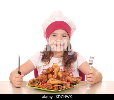 Kleines Mädchen Kochen mit Huhn Drumstick auf Platte bereit für Mittagessen Stockfoto