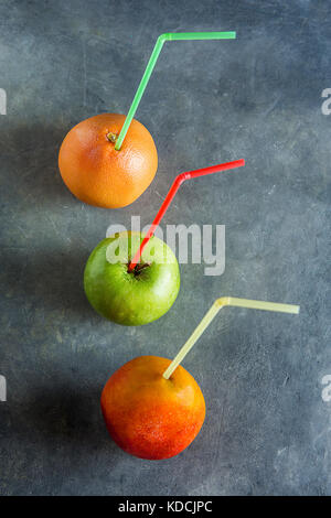 Reif Bio Früchte Mango grapefruit Apple mit Strohhalmen frische Säfte Gesundheit Entgiftung Konzept. dunklen Hintergrund Kopie Raum. Menü poster Vorlage Stockfoto