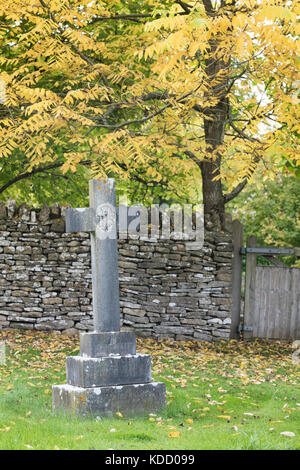 Kreuz Grabstein in St Andrew's Friedhof im Herbst, Naunton, Cotswolds, Gloucestershire, England Stockfoto