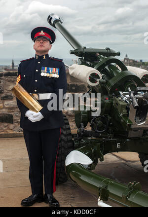 Bezirk Gunner Sergeant Dave Beveridge posiert mit leeren Schale nach dem Feuern die One o'clock Gun im Edinburgh Castle in Schottland. Stockfoto