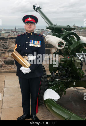 Bezirk Gunner Sergeant Dave Beveridge posiert mit leeren Schale nach dem Feuern die One o'clock Gun im Edinburgh Castle in Schottland. Stockfoto