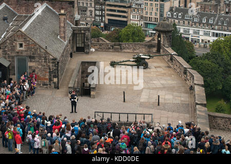 Bezirk Gunner Sergeant Dave Beveridge Adressen Besucher vor dem Zünden des One o'clock Gun im Edinburgh Castle in Schottland. Stockfoto