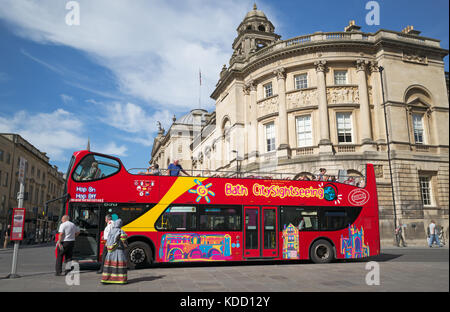 Top Double Decker Badewanne City Sightseeing Bus an der Haltestelle in der Orange Grove offen, mit Guildhall Gebäude hinter, Badewanne, Somerset, Großbritannien Stockfoto