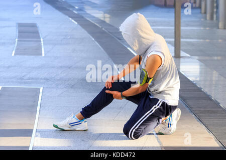 Junge Sportart mann Knie mit den Händen in den Schmerz nach Leiden Muskelverletzungen während eines laufenden Workout Stockfoto