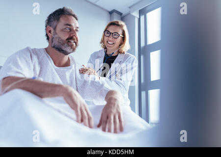 Ärztin Kontrolle der männlichen Patienten. Arzt besuchen und das Gespräch mit dem Patienten in einem Krankenhaus. Stockfoto