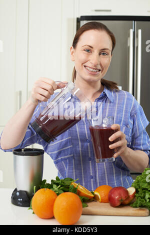 Porträt der Frau, Saft oder Smoothie in der Küche Stockfoto