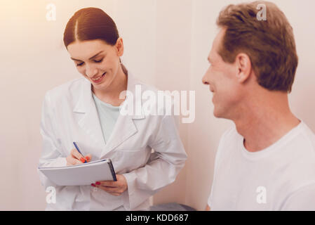 Aufmerksamen jungen Arzt Notizen zu machen Stockfoto