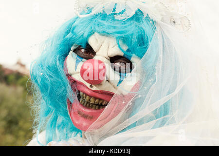 Nahaufnahme der Ein unheimlich bösen Clown draußen tragen eine Braut Kleid, mit einem Schleier und ein Diadem Stockfoto
