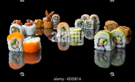 Vielfalt von bunten Sushi rollen auf einem schwarzen reflektierenden Hintergrund platziert Stockfoto