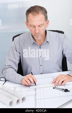 Porträt eines reifen Architekt Zeichnung plan auf Blueprint im Büro Stockfoto