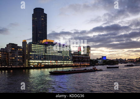 Londoner Southbank Skyline - Southbank Stadtbild - Themse Verkehr passieren Seecontainer Komplex und die Oxo Tower in der Dämmerung Stockfoto