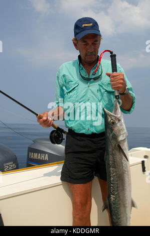 Ein Fischer mit einem kingfish oder König Makrele gefangen, während Fliegenfischen offshore von Freeport, Texas Stockfoto