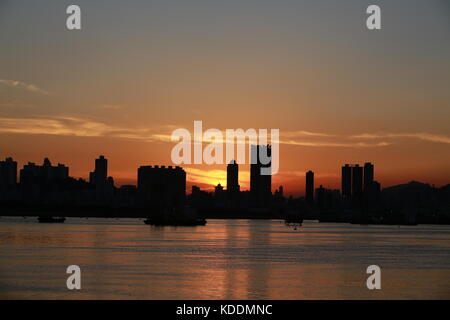 Victoria Harbour und die Skyline der Stadt: zwei Schichten von Silhouette Menschen und die Skyline der Stadt nach Stunde Stockfoto