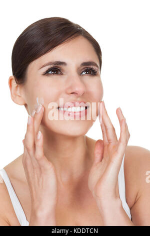 Pretty Young Woman Putting Cream Auf Ihre Haut Stockfoto
