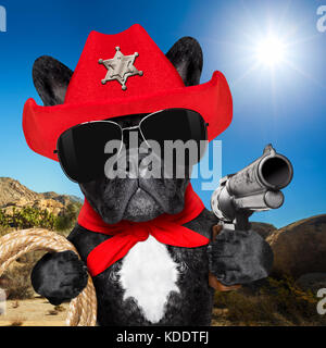 Western Cowboy Sheriff französische Bulldogge Hund mit Seil, roter Schal und Pistole draußen in der Wüste, das Tragen roter amerikanischer hat Stockfoto