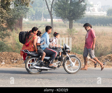 Shankar, panjab, Indien. 13. Oktober 2017. das Leben auf der Straße in Shankar, ländlichen indischen Dorf. Menschen in der morgendlichen Fahrt zur Schule und Arbeit. den Landwirten vor Ort ihre Ware durch Traktor. wenige Leute tragen Schutzhelme, so gibt es eine hohe Rate von Verletzungen und Unfällen Kredit: wansfordphoto/alamy leben Nachrichten Stockfoto