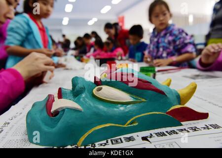 Enshi, China. Oktober 2017. Studenten lernen Masken der Nuo Opera in der Autonomen Präfektur Enshi Tujia und Miao in der zentralchinesischen Provinz Hubei zu machen. Masken sind ein charakteristisches Merkmal der Nuo-Oper, einem antiken Volksdrama, das in vielen chinesischen Provinzen entlang des Yangtse-Flusses immer noch beliebt ist. Es wird angenommen, dass die Darsteller der Nuo Opera die Fähigkeit erlangen, mit den Göttern zu kommunizieren, sobald sie ihre Masken tragen. Quelle: ZUMA Press, Inc./Alamy Live News Stockfoto
