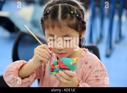 Enshi, China. Oktober 2017. Studenten lernen Masken der Nuo Opera in der Autonomen Präfektur Enshi Tujia und Miao in der zentralchinesischen Provinz Hubei zu machen. Masken sind ein charakteristisches Merkmal der Nuo-Oper, einem antiken Volksdrama, das in vielen chinesischen Provinzen entlang des Yangtse-Flusses immer noch beliebt ist. Es wird angenommen, dass die Darsteller der Nuo Opera die Fähigkeit erlangen, mit den Göttern zu kommunizieren, sobald sie ihre Masken tragen. Quelle: ZUMA Press, Inc./Alamy Live News Stockfoto
