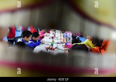 Enshi, China. Oktober 2017. Studenten lernen Masken der Nuo Opera in der Autonomen Präfektur Enshi Tujia und Miao in der zentralchinesischen Provinz Hubei zu machen. Masken sind ein charakteristisches Merkmal der Nuo-Oper, einem antiken Volksdrama, das in vielen chinesischen Provinzen entlang des Yangtse-Flusses immer noch beliebt ist. Es wird angenommen, dass die Darsteller der Nuo Opera die Fähigkeit erlangen, mit den Göttern zu kommunizieren, sobald sie ihre Masken tragen. Quelle: ZUMA Press, Inc./Alamy Live News Stockfoto