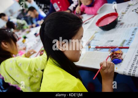 Enshi, China. Oktober 2017. Studenten lernen Masken der Nuo Opera in der Autonomen Präfektur Enshi Tujia und Miao in der zentralchinesischen Provinz Hubei zu machen. Masken sind ein charakteristisches Merkmal der Nuo-Oper, einem antiken Volksdrama, das in vielen chinesischen Provinzen entlang des Yangtse-Flusses immer noch beliebt ist. Es wird angenommen, dass die Darsteller der Nuo Opera die Fähigkeit erlangen, mit den Göttern zu kommunizieren, sobald sie ihre Masken tragen. Quelle: ZUMA Press, Inc./Alamy Live News Stockfoto