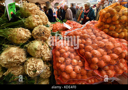 Weimar, Deutschland. Oktober 2017. Sellerie und Zwiebeln werden auf dem 364. Weimarer Zwiebelmarkt in Weimar am 13. Oktober 2017 verkauft. Das berühmteste Volksfest Thüringens zieht bis zum 15. Oktober rund 300,000 Besucher an. Rund 500 Stände bieten die beliebten rot-weiß geflochtenen Zwiebelbündel, warme Zwiebeltorte, Thüringer Bratwurst, Getränke und Kunsthandwerk an. Quelle: Martin Schutt/dpa-Zentralbild/dpa/Alamy Live News Stockfoto