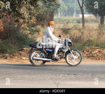 Shankar, panjab, Indien. 13 Okt, 2017. das Leben auf der Straße in Shankar, ländlichen indischen Dorf. Menschen in der morgendlichen Fahrt zur Schule und Arbeit. den Landwirten vor Ort ihre Ware durch Traktor. wenige Leute tragen Schutzhelme, so gibt es eine hohe Rate von Verletzungen und Unfällen Kredit: wansfordphoto/alamy leben Nachrichten Stockfoto