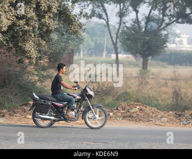 Shankar, panjab, Indien. 13 Okt, 2017. das Leben auf der Straße in Shankar, ländlichen indischen Dorf. Menschen in der morgendlichen Fahrt zur Schule und Arbeit. den Landwirten vor Ort ihre Ware durch Traktor. wenige Leute tragen Schutzhelme, so gibt es eine hohe Rate von Verletzungen und Unfällen Kredit: wansfordphoto/alamy leben Nachrichten Stockfoto