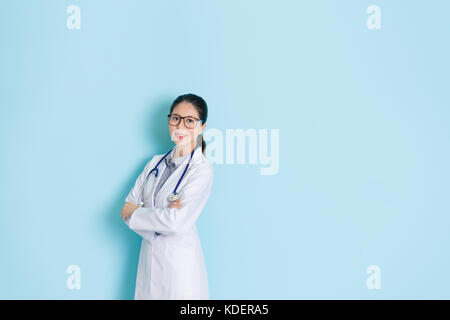 Sweet Pretty Rechte der Frau Doktor medical care Patient gesund und lächelndes Gesicht zur Kamera steht in blau Wand Hintergrund mit leeren Bereich. Stockfoto