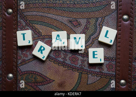 Reisen die Welt scrabble tiles Leder Koffer Hintergrund Stockfoto